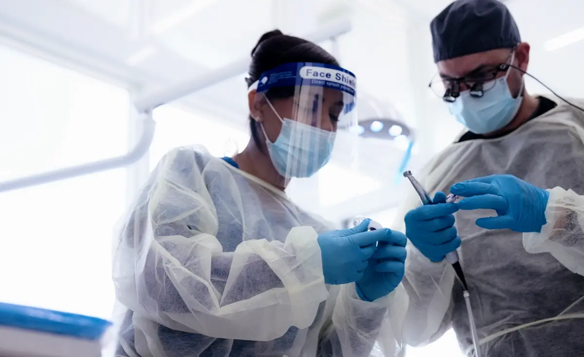 The dentist and a dental assistant preparing instruments in a Metropolitan Smile Design operatory