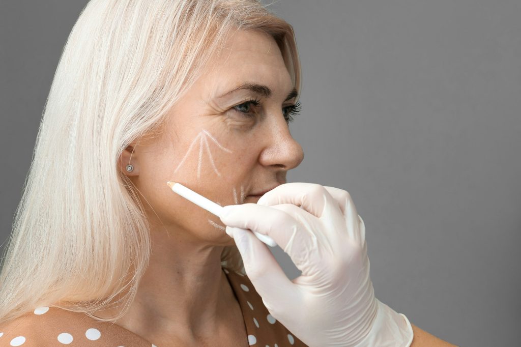 Marking the face with a white pencil for surgical intervention close-up