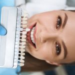 smiling woman is choosing veneers stock photo