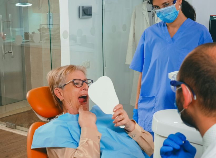 Woman with new dental implants looking in the mirror